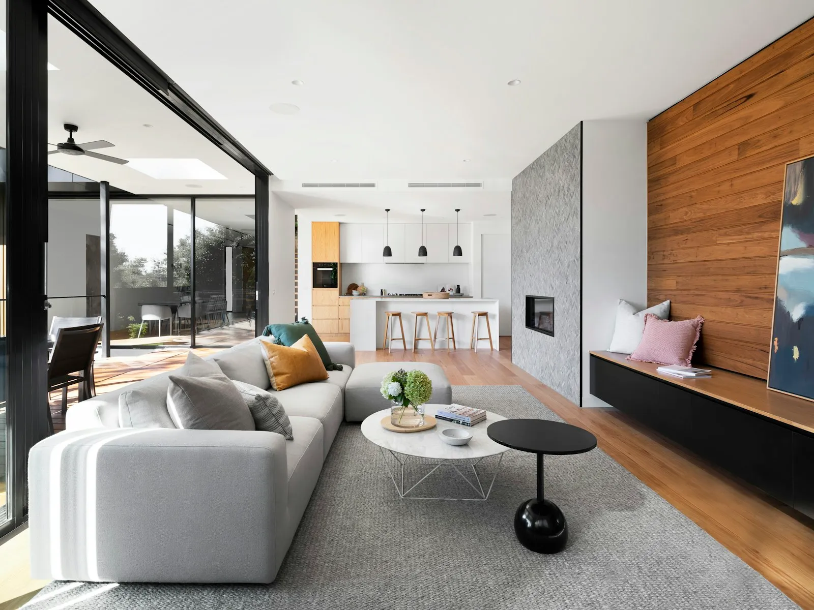 An open living room with a sectional sofa, wool rug and coffee table